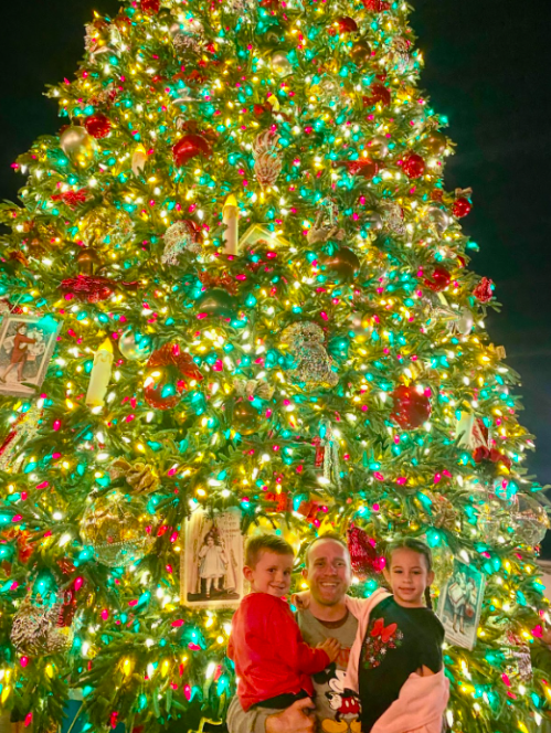 Mr.Cowell with his nephew and niece celebrating Christmas at Disneyland.