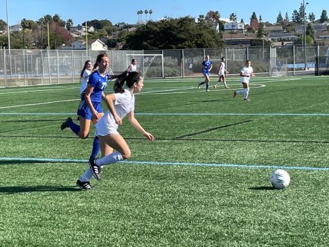 Eliana De Haro dribbles the ball up the field while trying to find an open teammate.