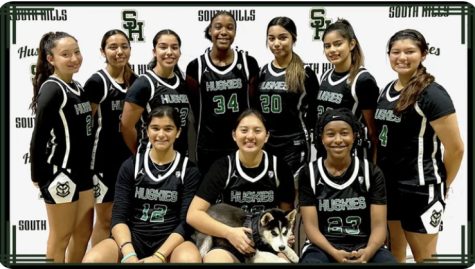 South Hills girls basketball players pose alongside Buddy, the coachs dog, for a team photo.