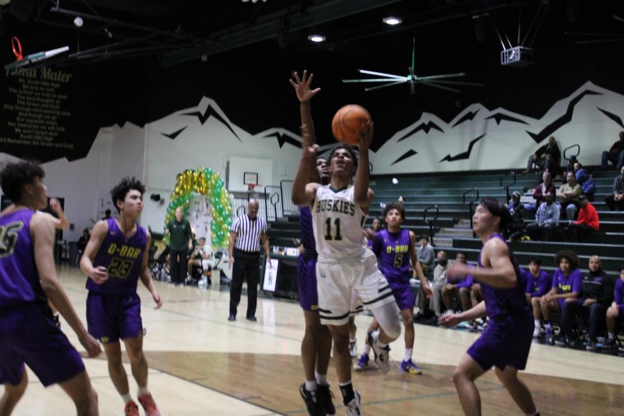 Sean Jones (10) dribbles past two defenders during senior night and finishes the layup with a contested shot.