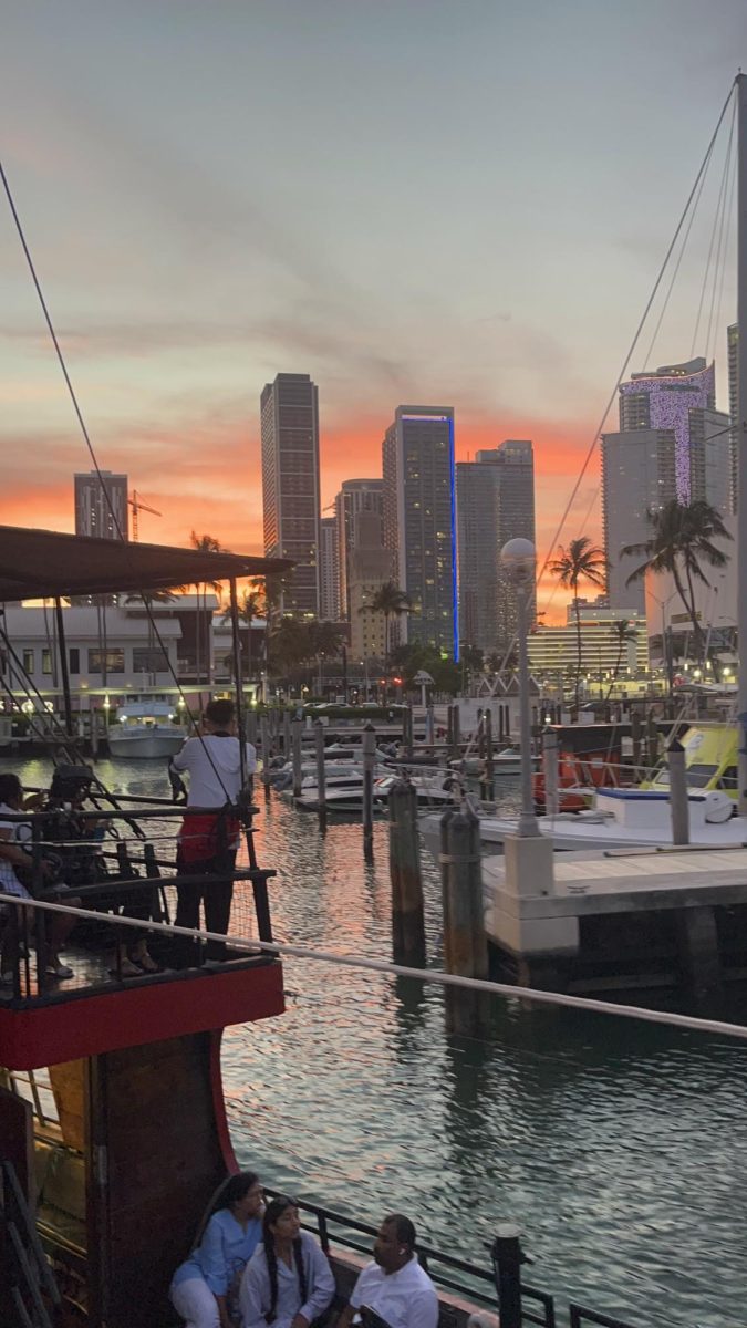 Abraham on a boat doing a tour around Miami seeing many famous houses.