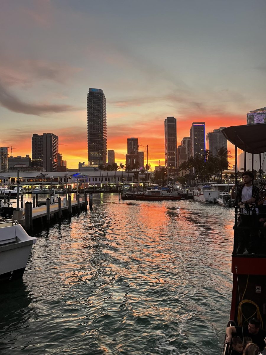 Abraham on a boat doing a tour around Miami seeing many famous houses.