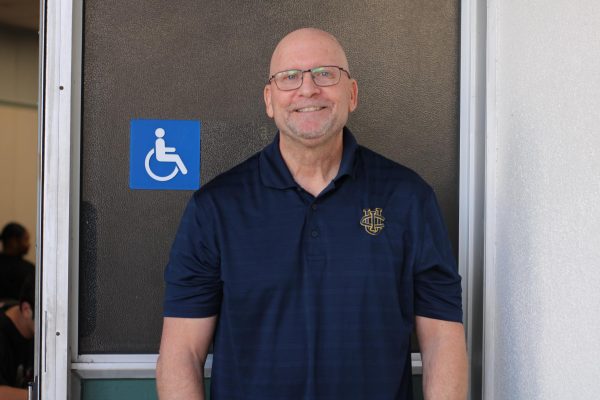 Mr. Shields poses for a photo in front of his classroom, room 105.