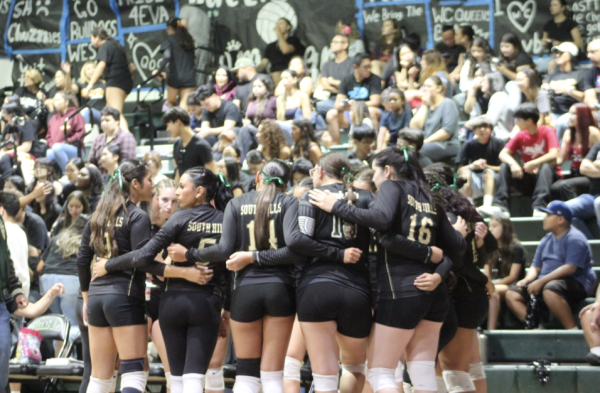 Varsity volleyball players huddle during Queens of Cameron game on Sept. 9.