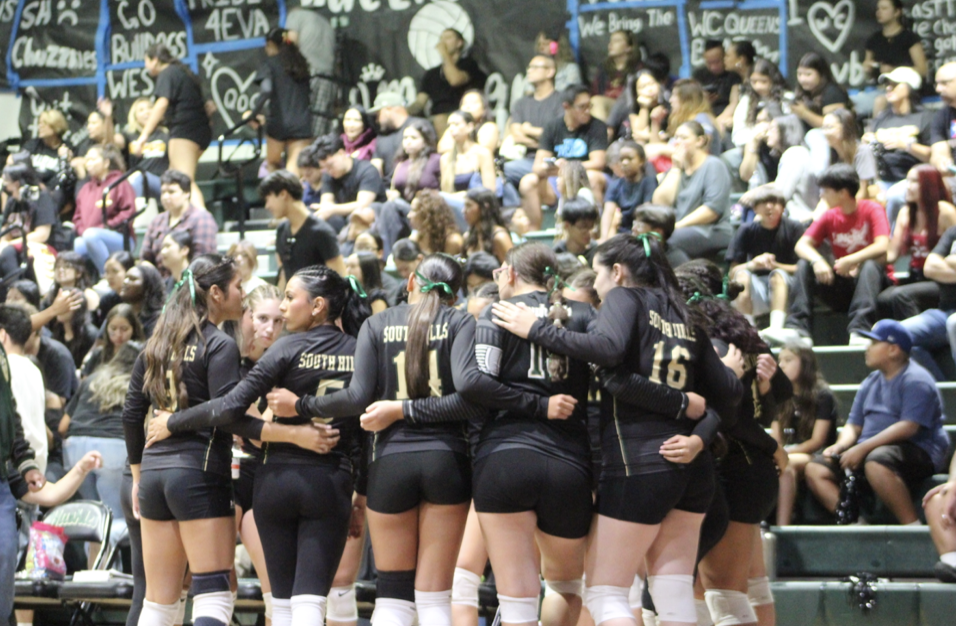 Varsity volleyball players huddle during Queens of Cameron game on Sept. 9.