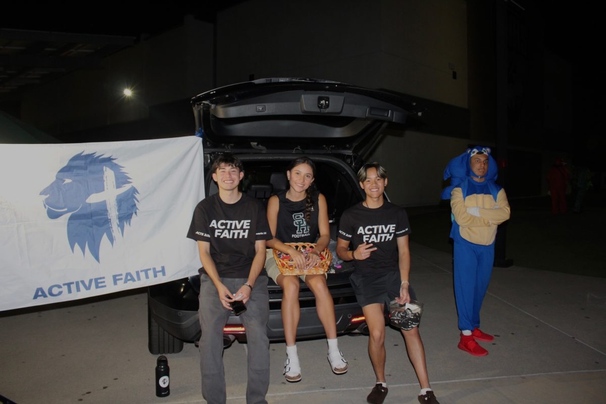 Active Faith cabinet members, Jordan Benavides (12), Brianna Castruita (12), and Nathan Lam (12) pose for a photo on Oct. 28 at the SHHS Husky Haunt while distributing candy and promoting their club.