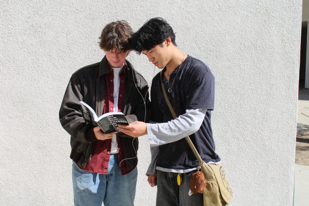 Hiram Pierce (11) ,left, and Ayden Sun (12), pose in their performative outfits as they read a serious book titled "The Film that Changed my Life" by Robert K. Elder.