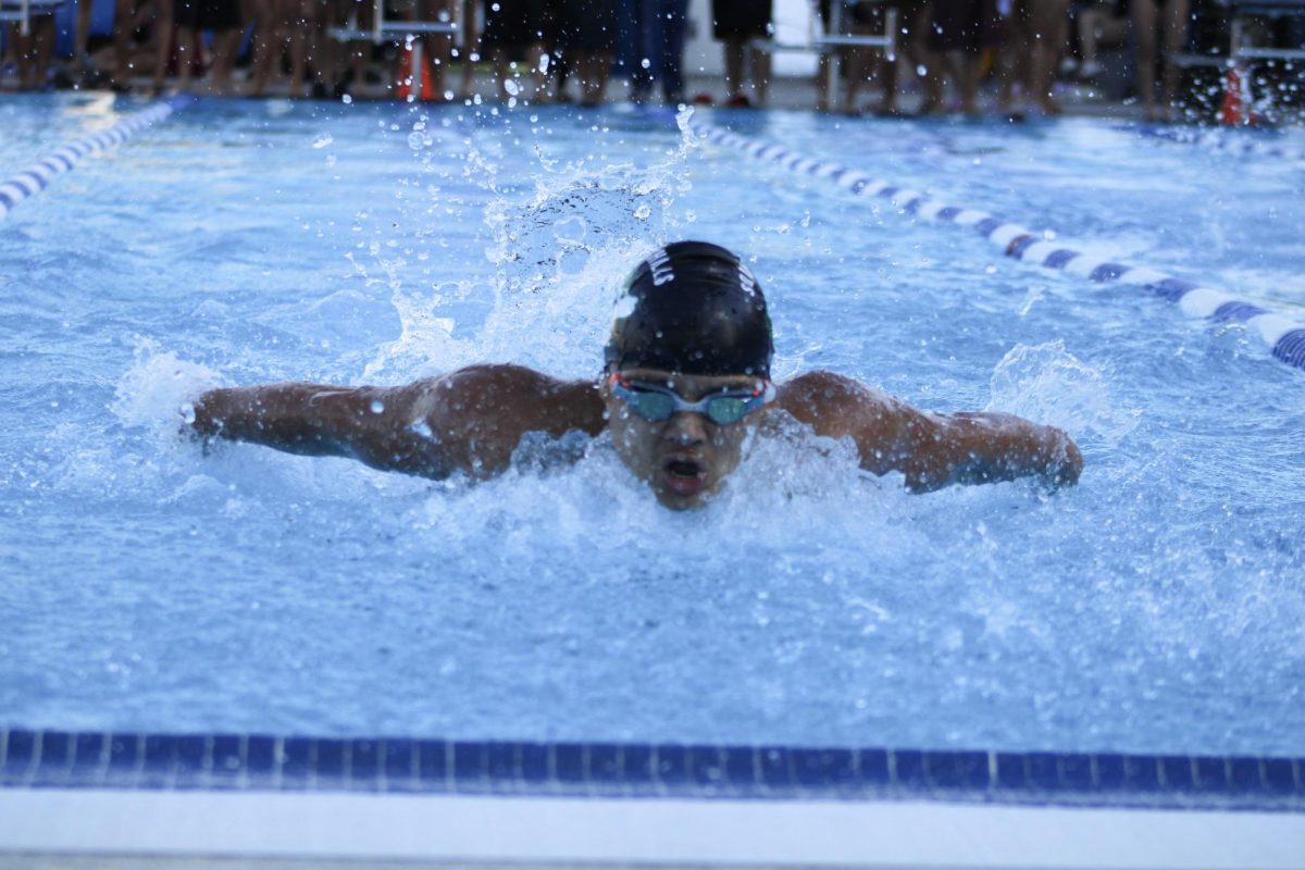 Varsity swimmer Jayden Phan (11) competes in the 100-yard butterfly against West Covina on March 3.