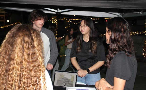 Students Hiram Pierce (11) and Megan Chong (12) present information about the IB program during Light Up the Night.